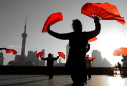 Shanghai China skyline with people dancing holding red cloth